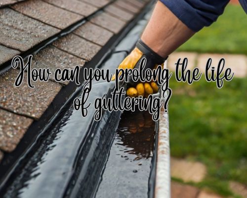 a roofer doing gutter maintenance to prolong the gutter's life span